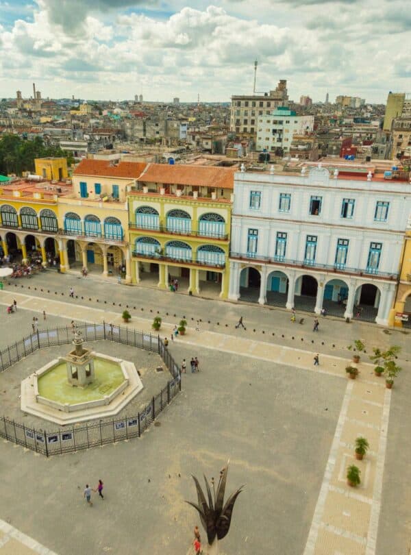 Historic Pangaea Plaza with colorful colonial buildings and central fountain in Havana, Cuba.