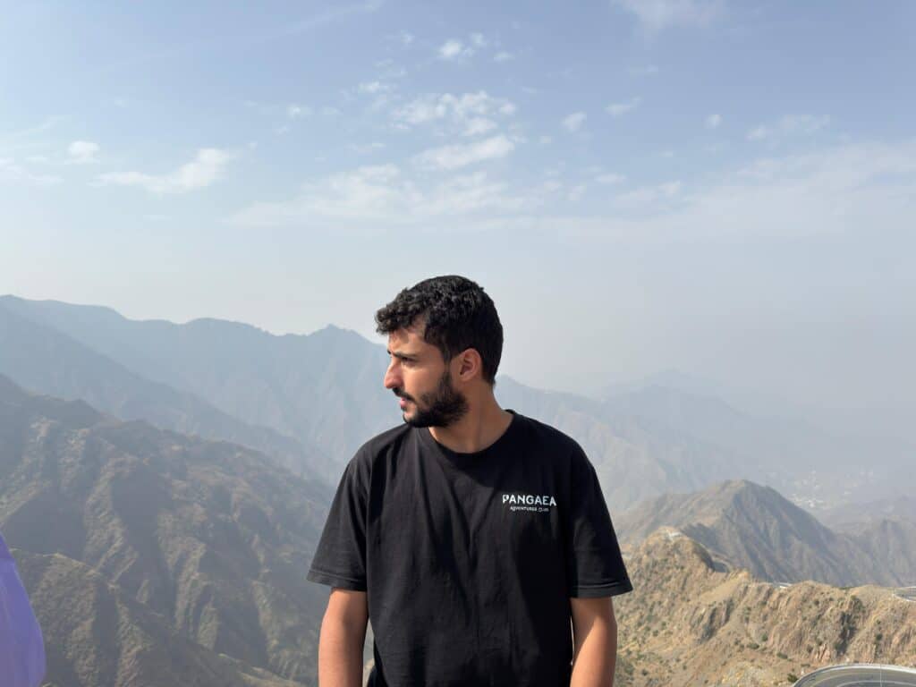 Young man enjoying mountain view at Pangaea outdoor adventure site.