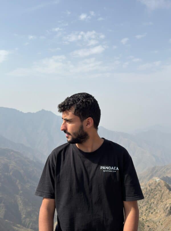 Young man enjoying mountain view at Pangaea outdoor adventure site.