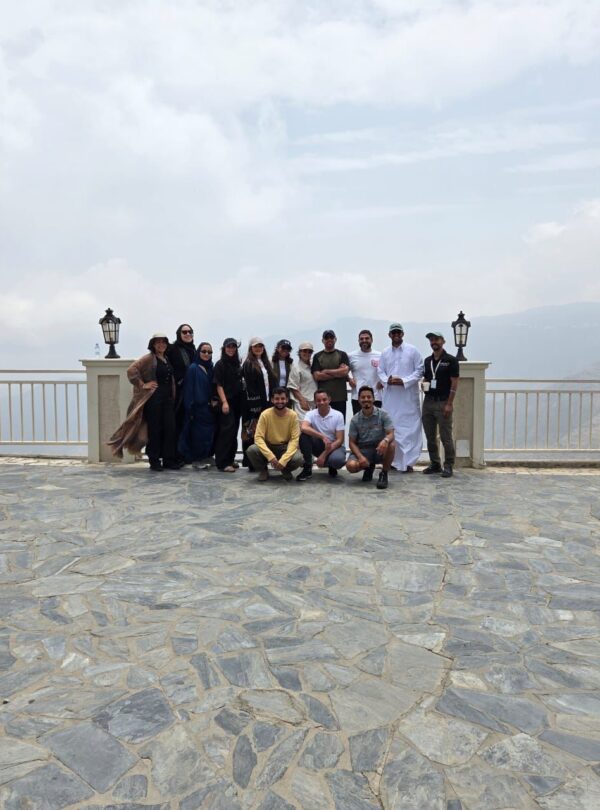 Group of people enjoying a scenic view at Pangaea with cloudy sky and ocean backdrop.